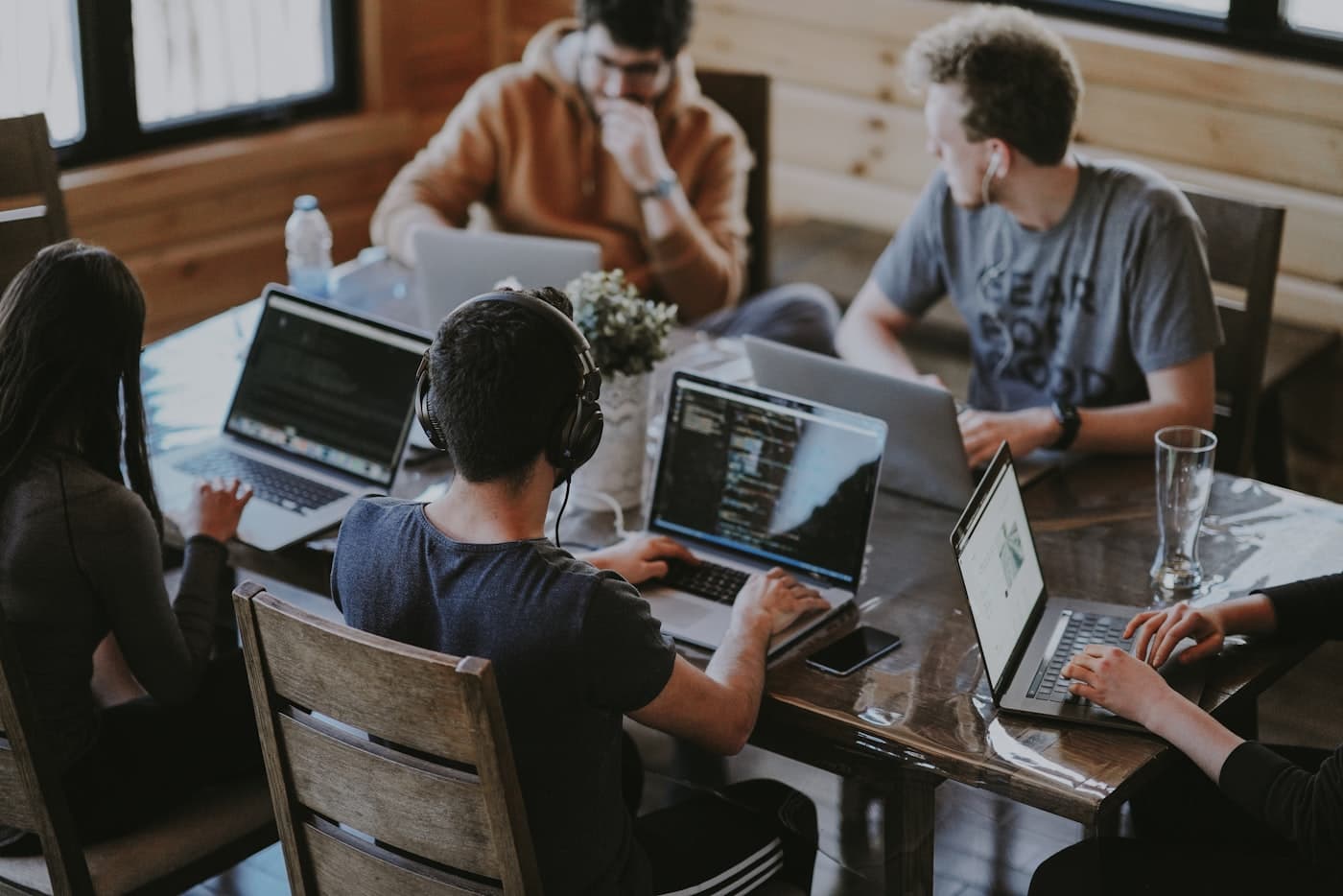 Developers working at laptops along a shared desk