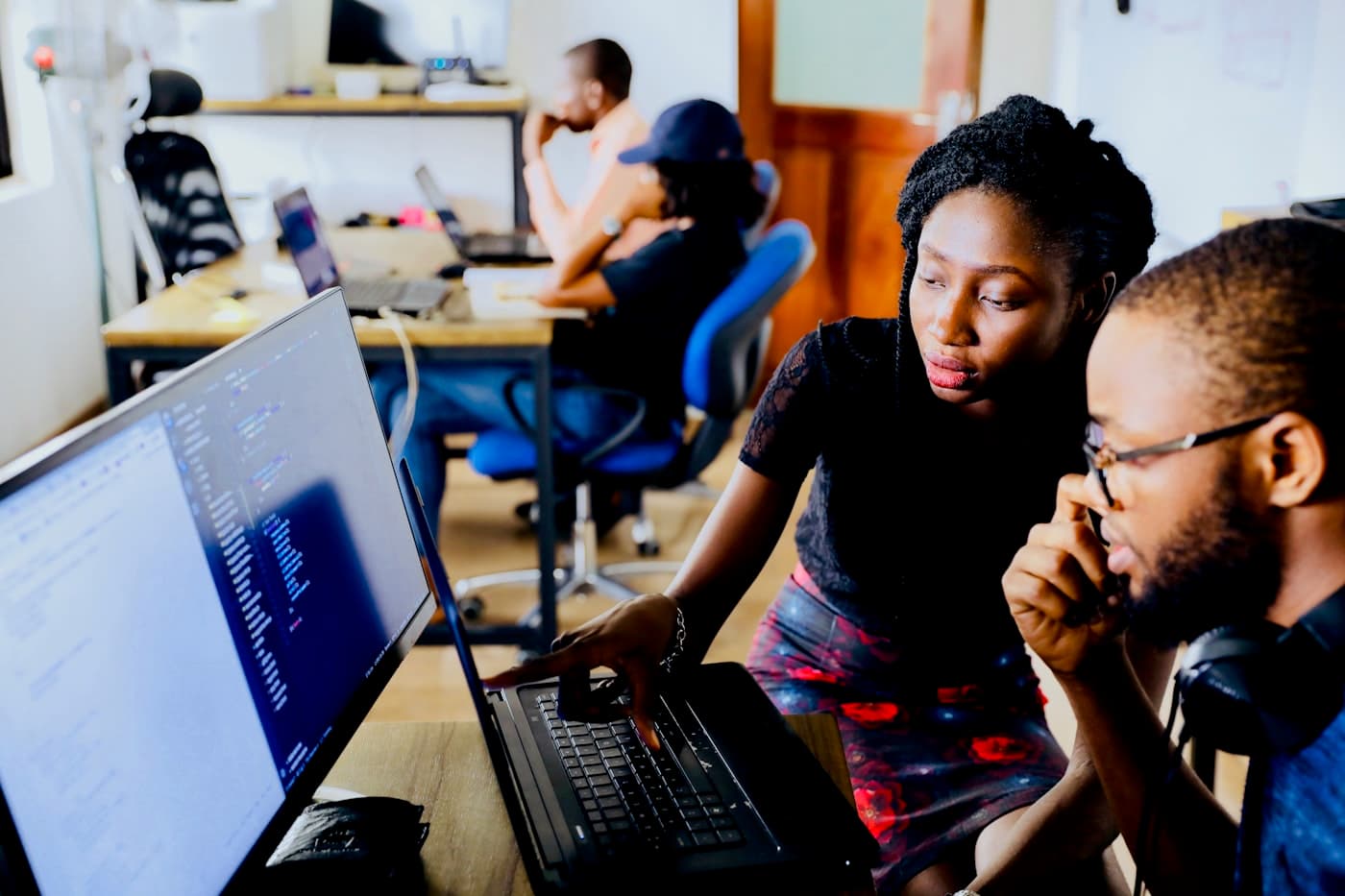 Two colleagues reviewing code together at one screen