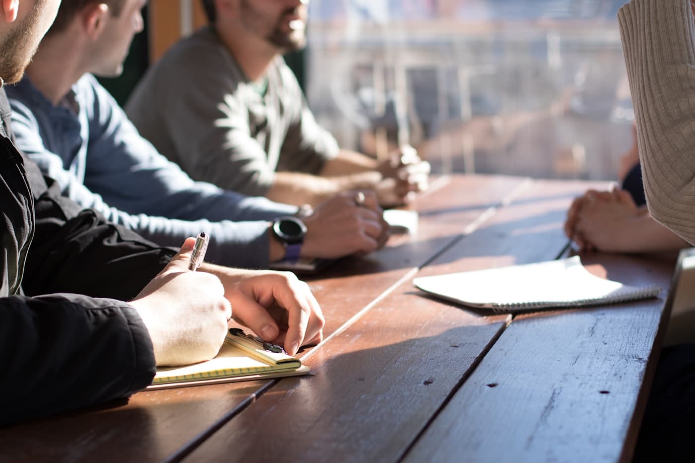 Colleagues taking notes together around a table